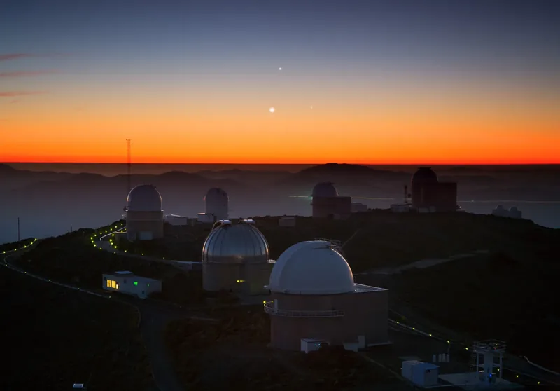 Jupiter, Vénus et Mercure brillent au crépuscule au-dessus des coupoles de La Silla