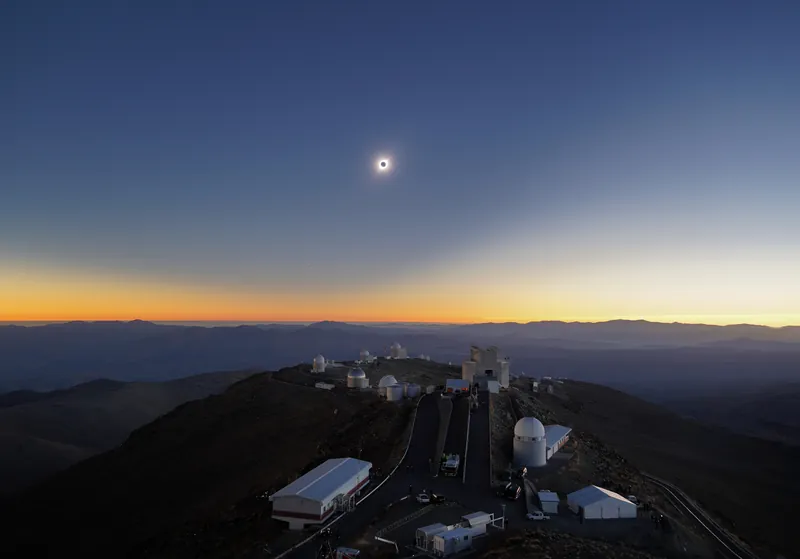 Le ciel bleu et orangé d’une éclipse totale de Soleil au-dessus des coupoles de La Silla