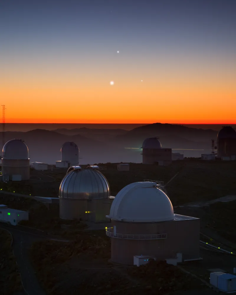 Jupiter, Vénus et Mercure brillent dans le ciel du crépuscule au-dessus des coupoles de l’observatoire de La Silla