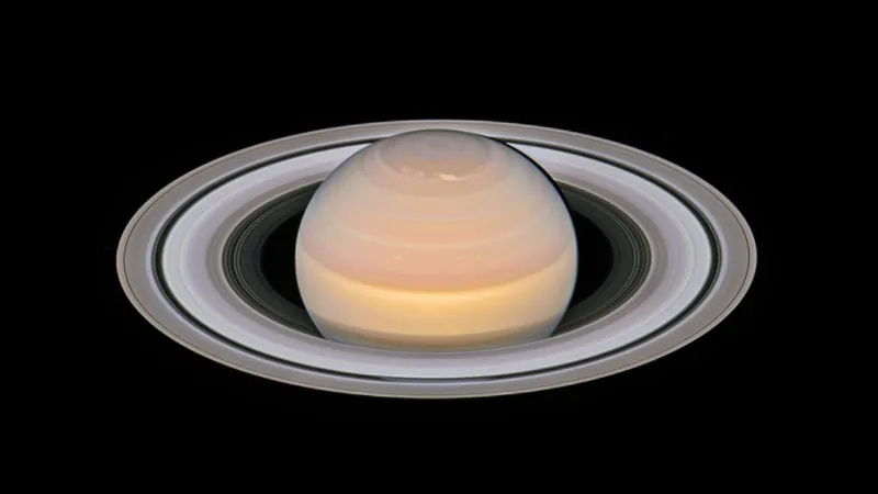 Saturne photographiée par Hubble en 2018 : un globe crème strié de bandes de nuages et ses anneaux largement ouverts