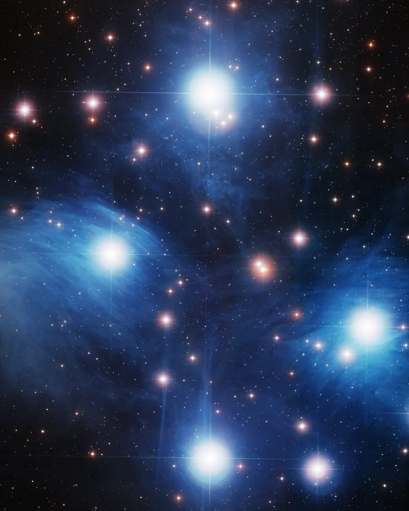 Le cœur de l’amas des Pléiades : une dizaine d’étoiles bleu-blanc enveloppées d’une nébulosité bleue filamenteuse