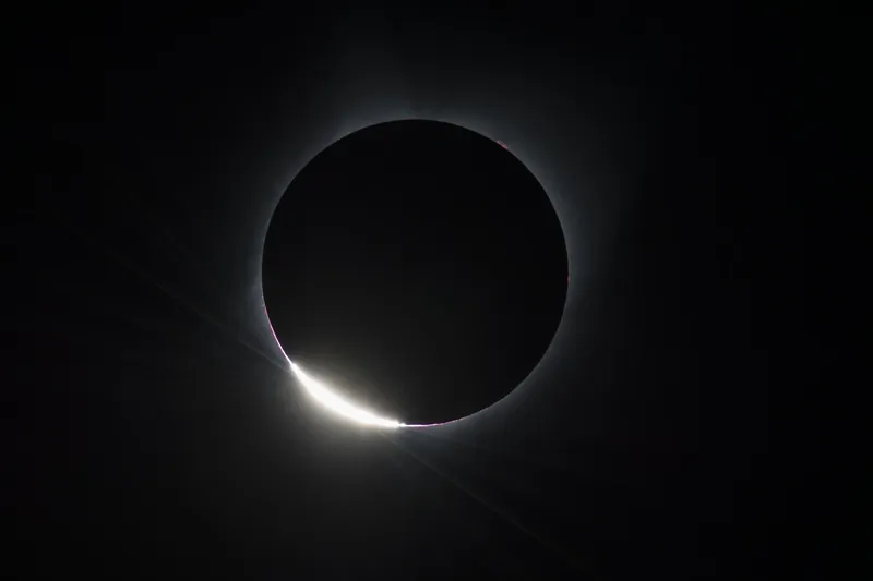 Dernier éclat du Soleil au bord de la Lune noire : l’« anneau de diamant » d’une éclipse totale, sur fond de ciel noir