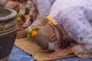 Cérémonie d’ordination bouddhiste, un homme incliné pendant le rituel
