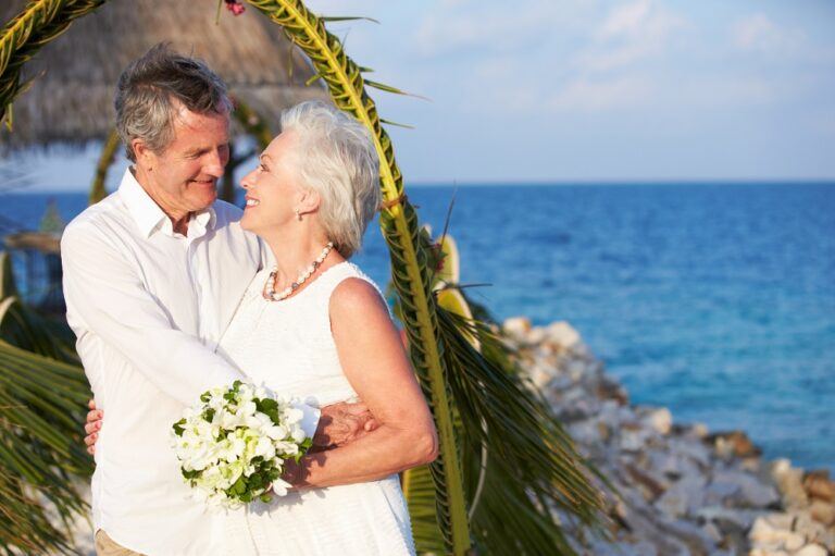 Couple de jeunes mariés seniors souriants au bord de la mer