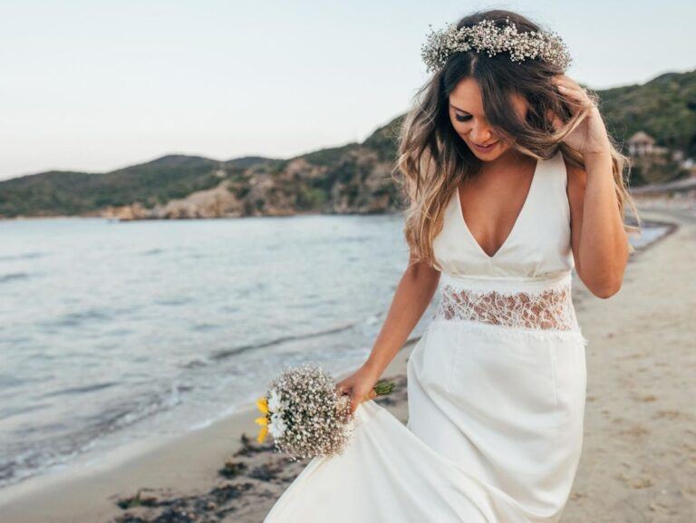 Mariée en robe bohème au décolleté en V et couronne de fleurs sur une plage