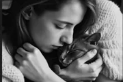 Femme embrassant son chat blotti dans ses bras, photo en noir et blanc