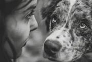 Jeune femme et son chien tacheté face à face, photo en noir et blanc