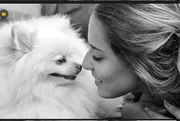 Femme et son petit chien blanc nez à nez, photo en noir et blanc