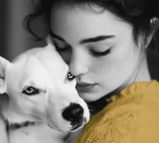 Portrait d’une jeune femme et de son chien blanc, joue contre joue