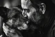 Homme âgé embrassant son vieux chien, portrait émouvant en noir et blanc