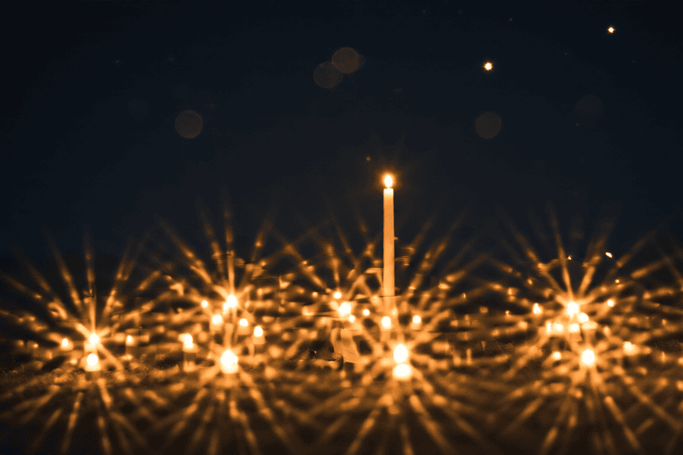 Bougies et étincelles dorées dans la nuit, lumière d’hommage