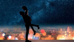 Couple enlacé sous un ciel étoilé au-dessus des lumières de la ville